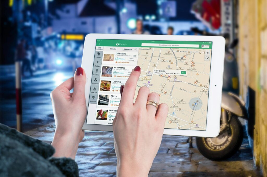 Hands using a digital map on a tablet in an urban setting at night, illustrating navigation and technology. local seo audit